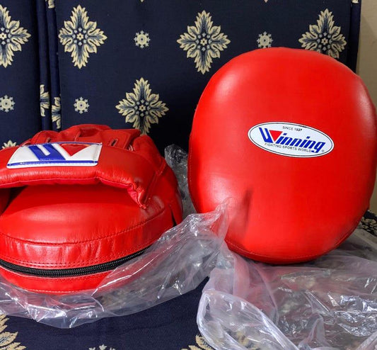 Red boxing punch mitts with 'Winning' logo